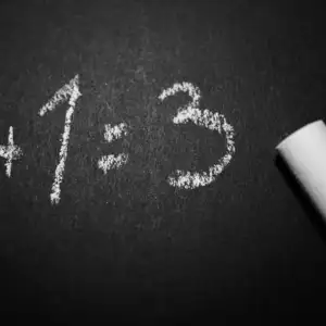 A black board with 1 + 1 = 2 written on it in white chalk