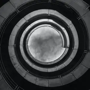 Looking up at the sky from the centre of a spiralling building